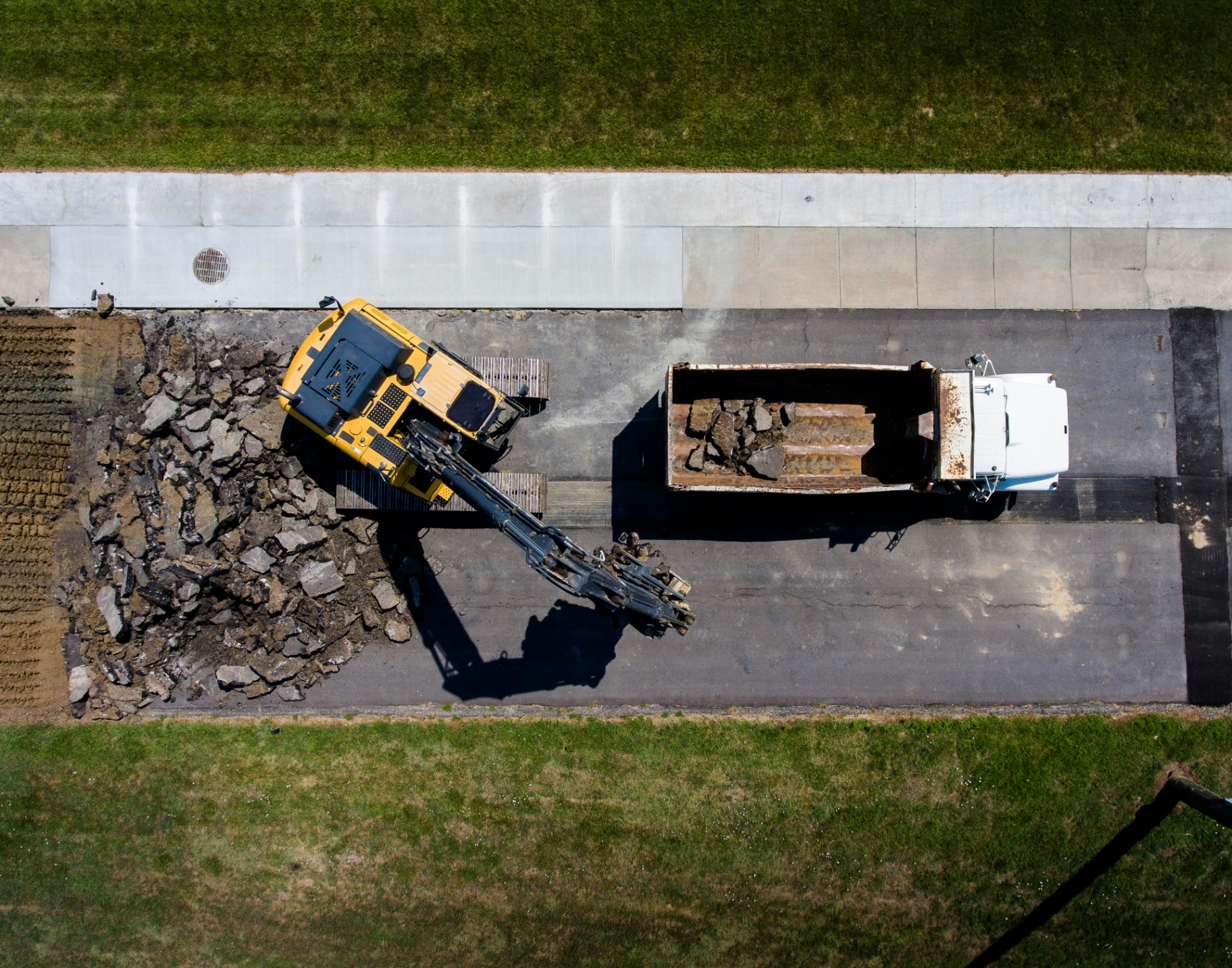 Aerial view of construction equipment loading debris into a truck